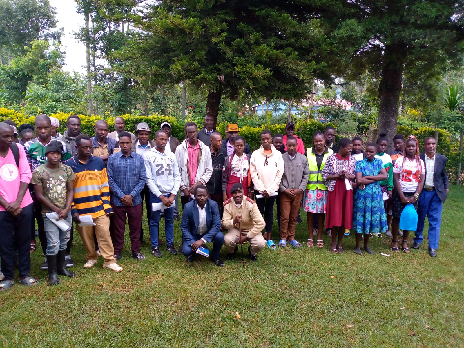 Group of Emgwen TVC students, staff and guests posing together outdoors for a photo after a campus outreach session.