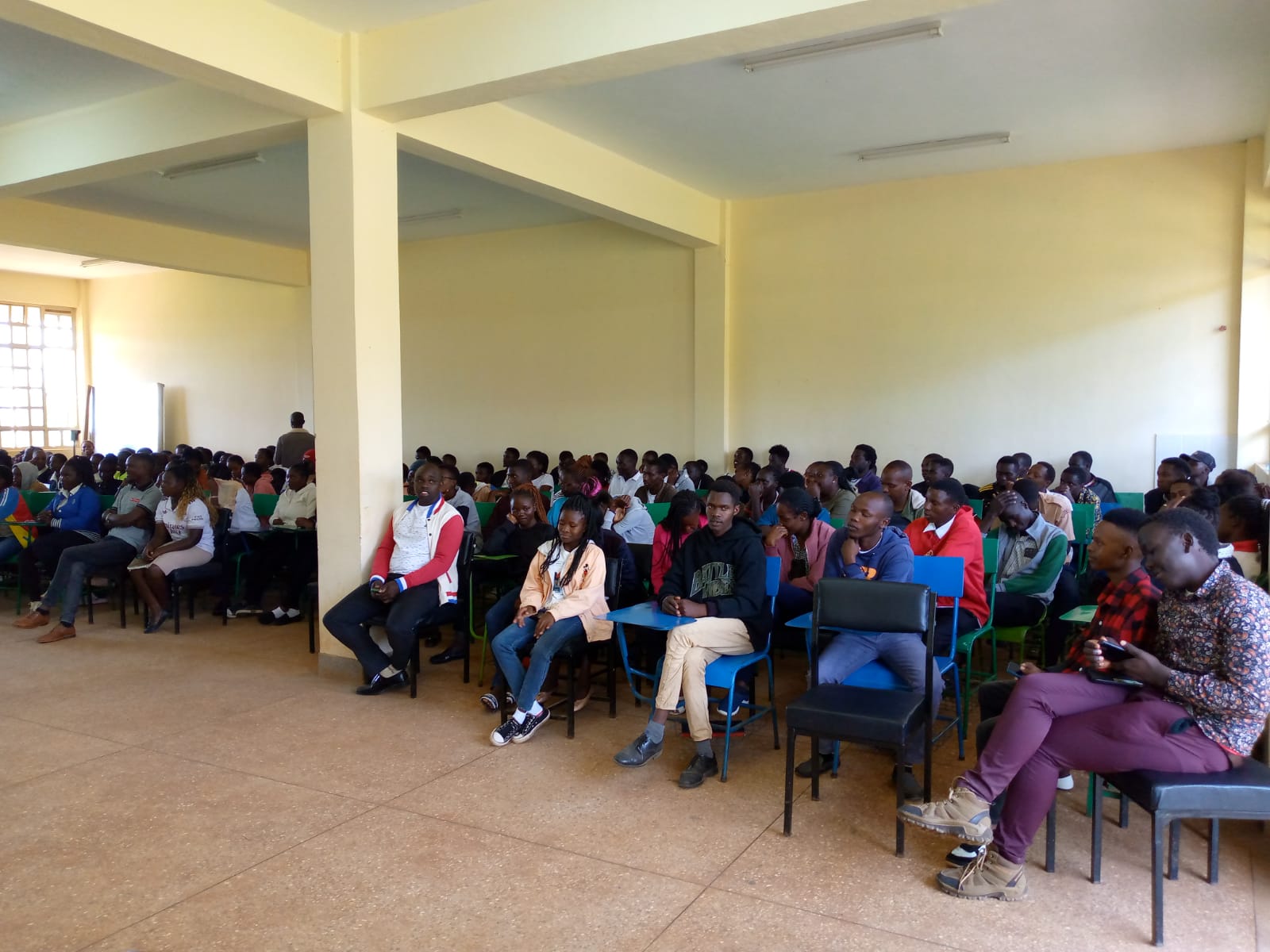 Large group of students seated indoors in an Emgwen TVC hall while attending an orientation session.